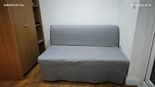 a gray chair sitting in a room next to a door at Private guest suite inside a family home with own entrance, kitchen, and bathroom in High Wycombe
