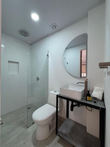 a bathroom with a toilet and a sink and a mirror at Casa Bosque Vivo in Norcasia