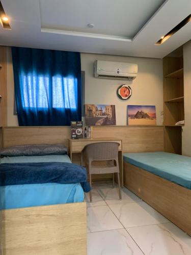 a bedroom with two twin beds and a desk at بن صالح للاستديوهات والشقق المفروشة in 6th Of October