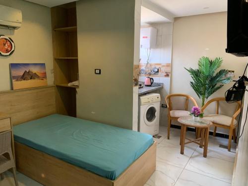 a small room with a bed and a washing machine at بن صالح للاستديوهات والشقق المفروشة in 6th Of October