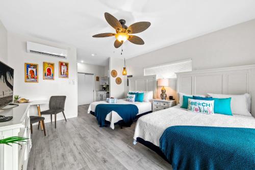 ein Schlafzimmer mit zwei Betten und einem Deckenventilator in der Unterkunft The No Problem at Cottages in Sand Bluff