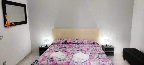 チビタベッキアにあるPetit Bijouのベッドルーム1室(花柄のベッドカバー付)