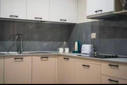 a kitchen with white cabinets and a sink at Class Apartments in Tirana