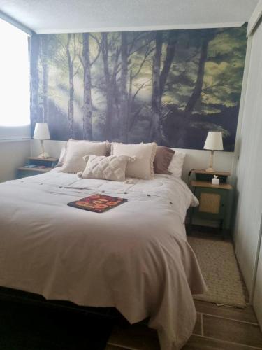 a bedroom with a large bed with a painting on the wall at Martin Pescador in Puerto Montt