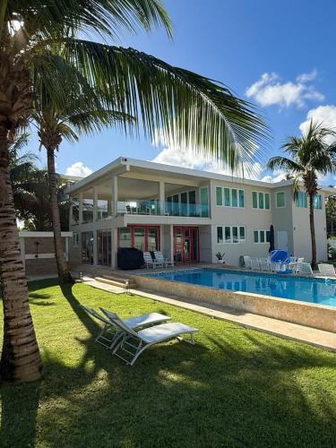 a house with a pool and a palm tree at Beachfront Spacious Luxury Villa Private Pool in Fortuna