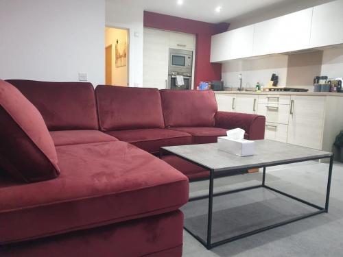 a living room with a red couch and a table at Oatlands Oasis-FREE PARKING-2 Minutes from M74 in Glasgow