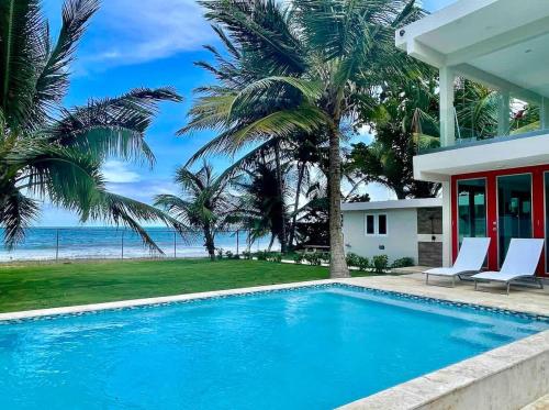 Una piscina frente a una casa con vistas al océano en Beachfront Spacious Luxury Villa Private Pool, en Playa Fortuna
