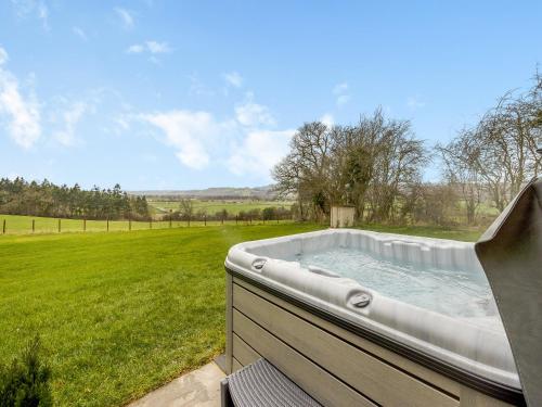 a hot tub in the middle of a field at Hope Hideaway 