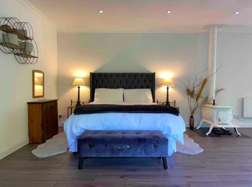 a bedroom with a large bed and two lamps at Charming Country Retreat -Lake View Cottage with Hot tub in Wisbech Saint Mary