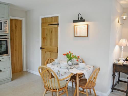 ein Esszimmer mit einem Tisch mit Stühlen und einem Tisch in der Unterkunft Cox Cottage - Pqqq in Pembury