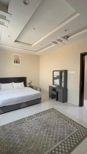 a bedroom with a bed and a mirror and a rug at شقة غرفة نوم وصالة in Jazan