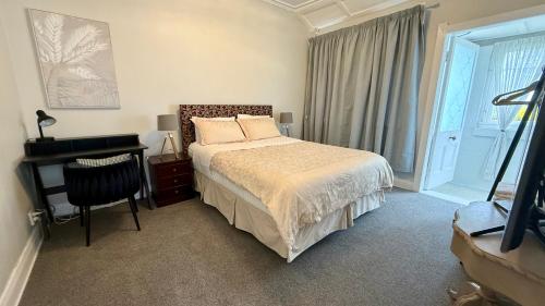 a bedroom with a bed and a desk and a window at Central Spot Elegant Home Fresh Features in Auckland