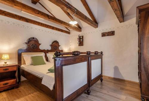 een slaapkamer met een bed met een houten hoofdeinde bij Villa Nostalgia pool & wellness in Gračišče
