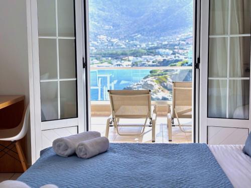 a bedroom with a bed and a balcony with a view at Villa Vasilis in Bali