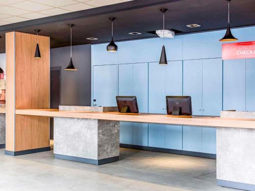 a lobby with a counter with two computers on it at ibis Sao Paulo Ibirapuera in São Paulo