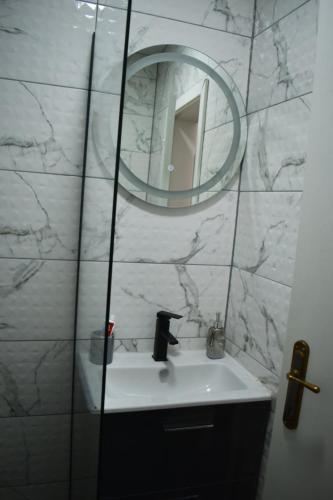 a bathroom with a sink and a mirror at Apartman Palermo in Višegrad