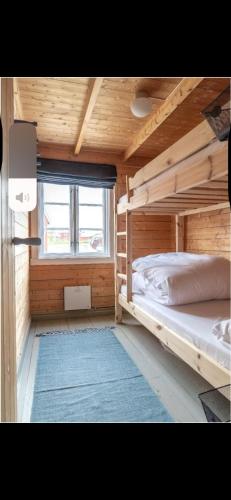a bedroom with two bunk beds and a window at Stinebua in Vestvågøya