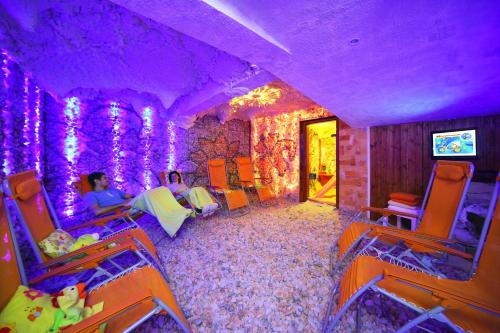 a room with purple lighting and a room with chairs at Resort Špindl in Špindlerův Mlýn