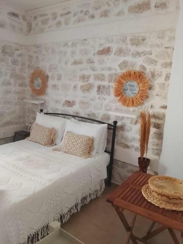 a bedroom with a white bed and a table at Afroessa Apartment Ithaca ΙΙ in Vathi, Ithaka