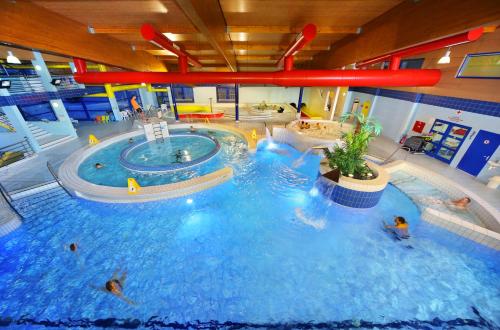 a large indoor swimming pool with people in it at Resort Špindl in Špindlerův Mlýn