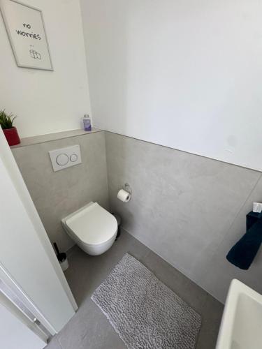 a bathroom with a toilet and a sink and a rug at UZ Villa 11 - Modern Living Laatzen in Hannover