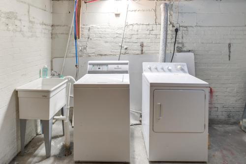 a white kitchen with a sink and a stove at Central Akron Stay! Large Victorian Home with Yard in Akron