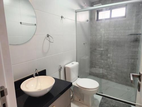 a bathroom with a toilet and a sink and a shower at Sua estadia a 350m da Praia em prédio c/ piscina na melhor localização de Cabedelo-PB | PTAs in Ilha da Restinga