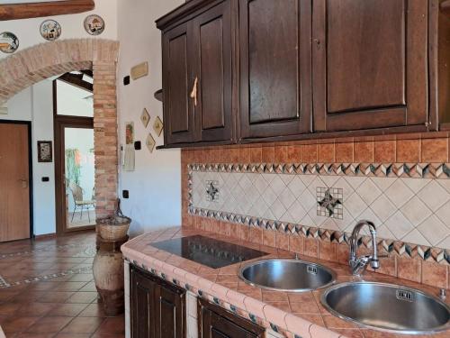 a kitchen with wooden cabinets and a sink at BlueHorizon in Santa Teresa di Riva