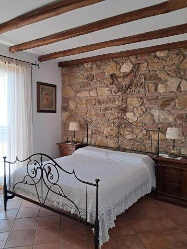 a bedroom with a stone wall and a bed at BlueHorizon in Santa Teresa di Riva