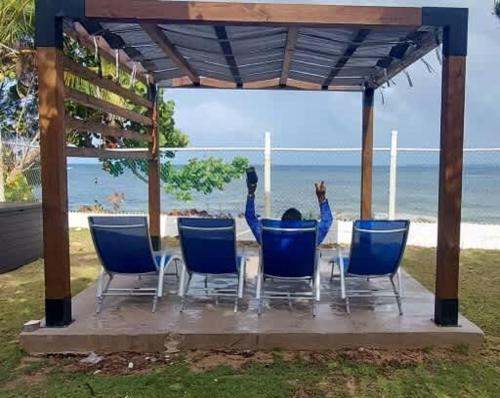 una persona sentada en una mesa mirando hacia el océano en Beachfront Spacious Home Private Luxury Pool, en Las Coles