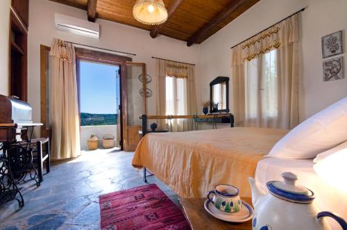 a bedroom with a large bed and a large window at Kallimento-Dimitra in Kissamos