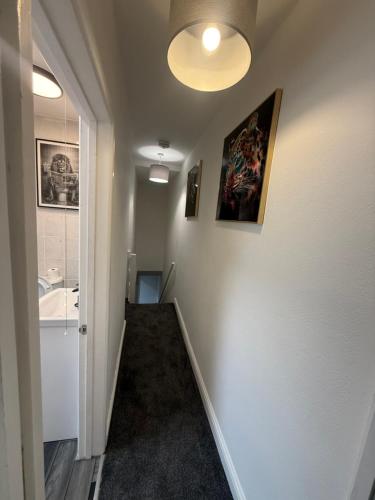 Un pasillo con un baño con lavabo y espejo. en Blaenavon Luxury Home, en Blaenavon