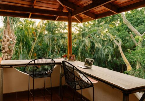 una mesa de exterior con dos sillas y un ordenador portátil encima. en Salty Enthusiasts Share House & Villas, en Santa Teresa Beach