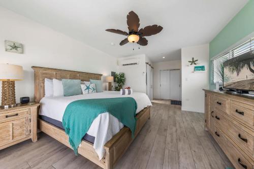 ein Schlafzimmer mit einem großen Bett und einem Deckenventilator in der Unterkunft The Starfish at Cottages in Sand Bluff