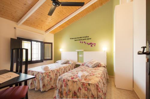 a room with two beds and a table and a ceiling at Un Rincón en la Mancha in Villar de Cañas