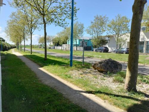 een pad in een park met bomen en een rots bij Appartement avec parking privé in Aytré