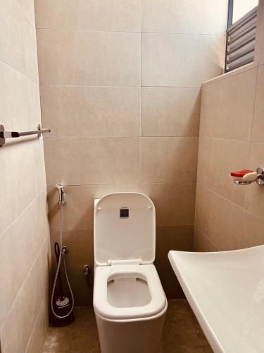a small bathroom with a toilet and a sink at Bright 3-Bed Flat with Balcony with Great Value in Sri Jayewardenepura Kotte