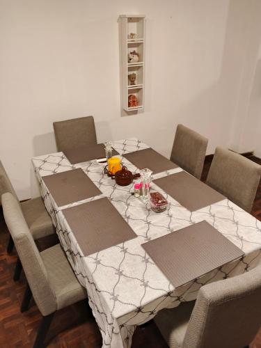 einen Esstisch mit Stühlen und einem weißen Tischtuch in der Unterkunft Amplio departamento para 10 personas in Cuenca