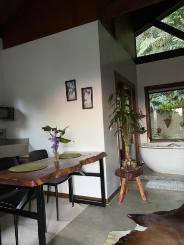 a room with a table and a bath tub at Chalé Au Clair de Lune Terê in Teresópolis