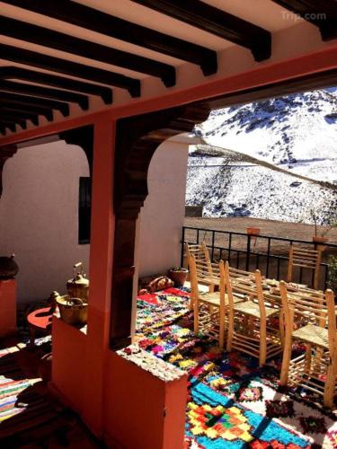 a dining room with a view of a snow covered mountain at Gite Likemte Tachdirt in Tacheddirt