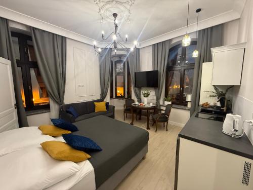 a bedroom with a large bed and a dining room at Apartamenty PREMIUM Rynek 21 in Toruń