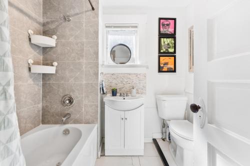 a bathroom with a tub and a sink and a toilet at Heritage Home in Heart of City with free Parking in Vancouver