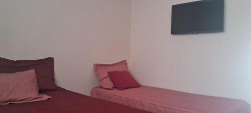 a room with two beds and a flat screen tv at Conforto e Lazer no Coração da Ilha de São Luís in São-José-do-Ribamar