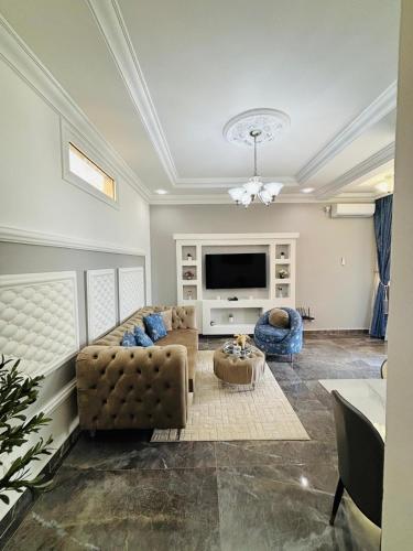 a living room with a couch and a tv at Résidence Bethel in Libreville