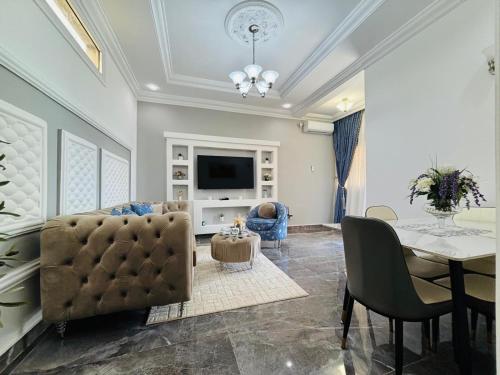 a living room with a couch and a table and a television at Résidence Bethel in Libreville