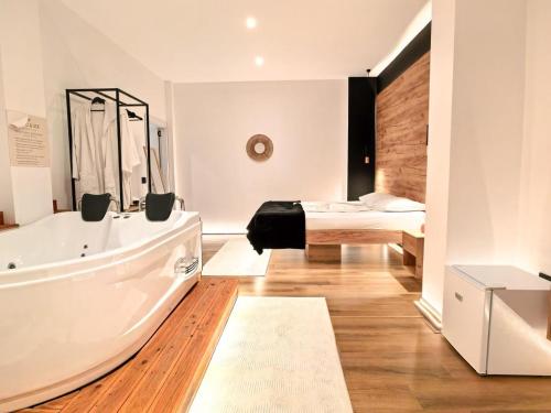 a bathroom with a bath tub and a bed at Jacuzzi Studio Room in Shkodër