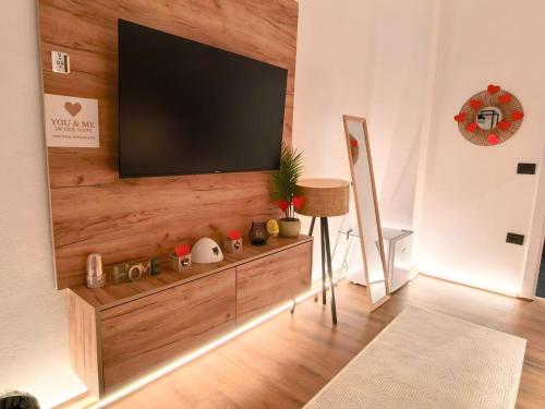 a living room with a flat screen tv on a wall at Jacuzzi Studio Room in Shkodër