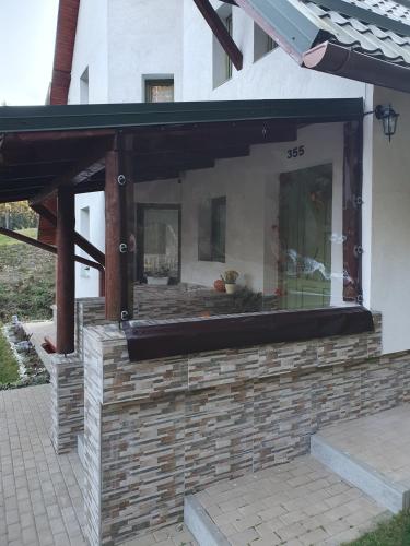 a building with awning on a brick patio at Star Panzió in Harghita-Băi