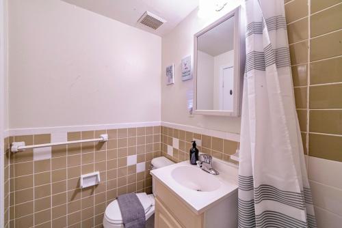 a bathroom with a sink and a toilet and a mirror at Cozy Studio near MassArt & Longwood, 3-Min Walk to T in Boston