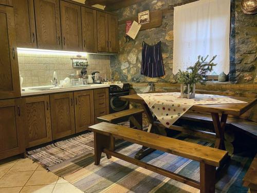a kitchen with a table and benches in it at Elato Stone House in Panayítsa
